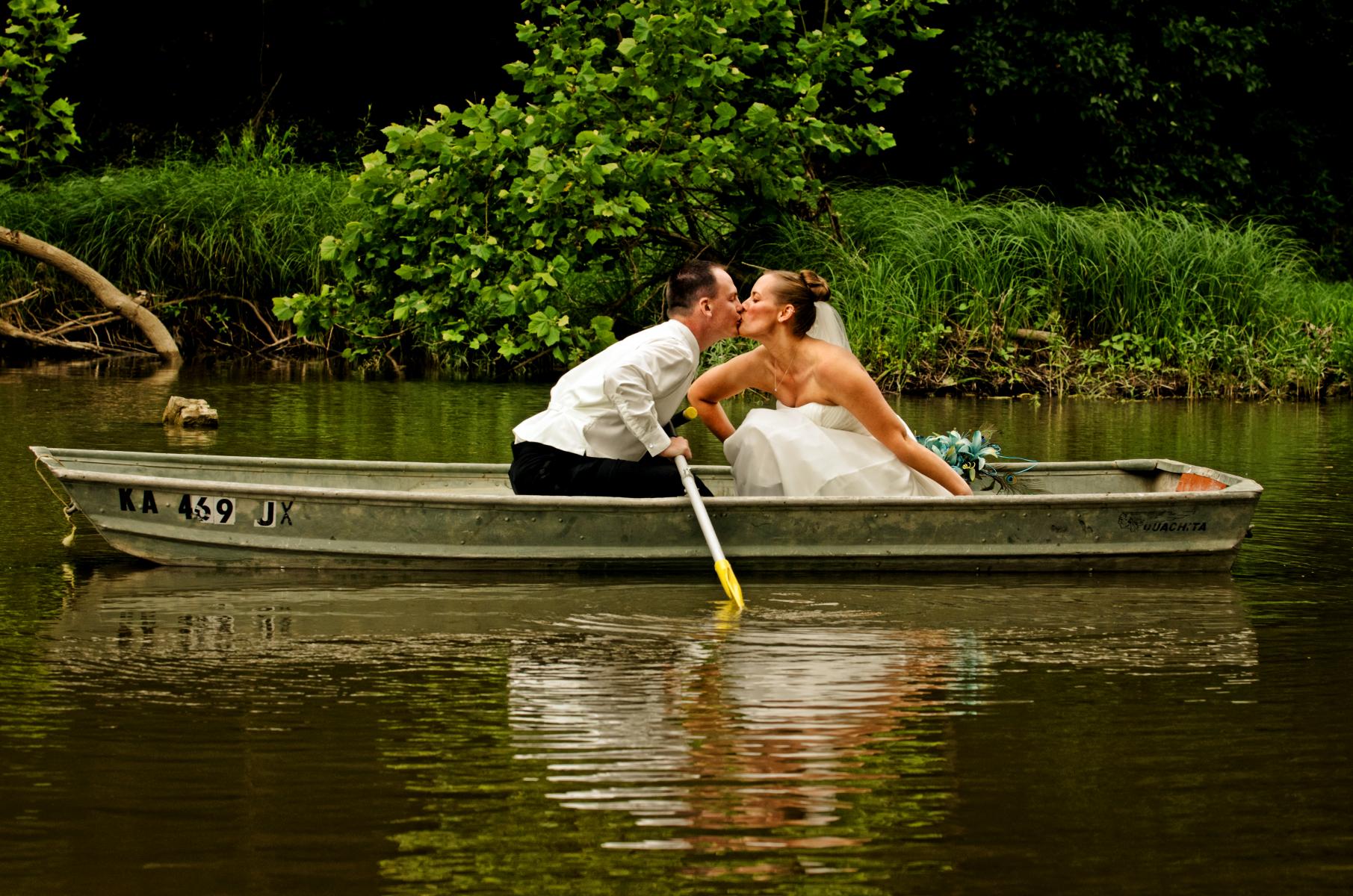 This fine art image tells the story of two lovebirds feeling their love for each other as they drift down a quiet river on a beautiful summer day, by Robertsons' Warehouse Photography, Wichita, KS