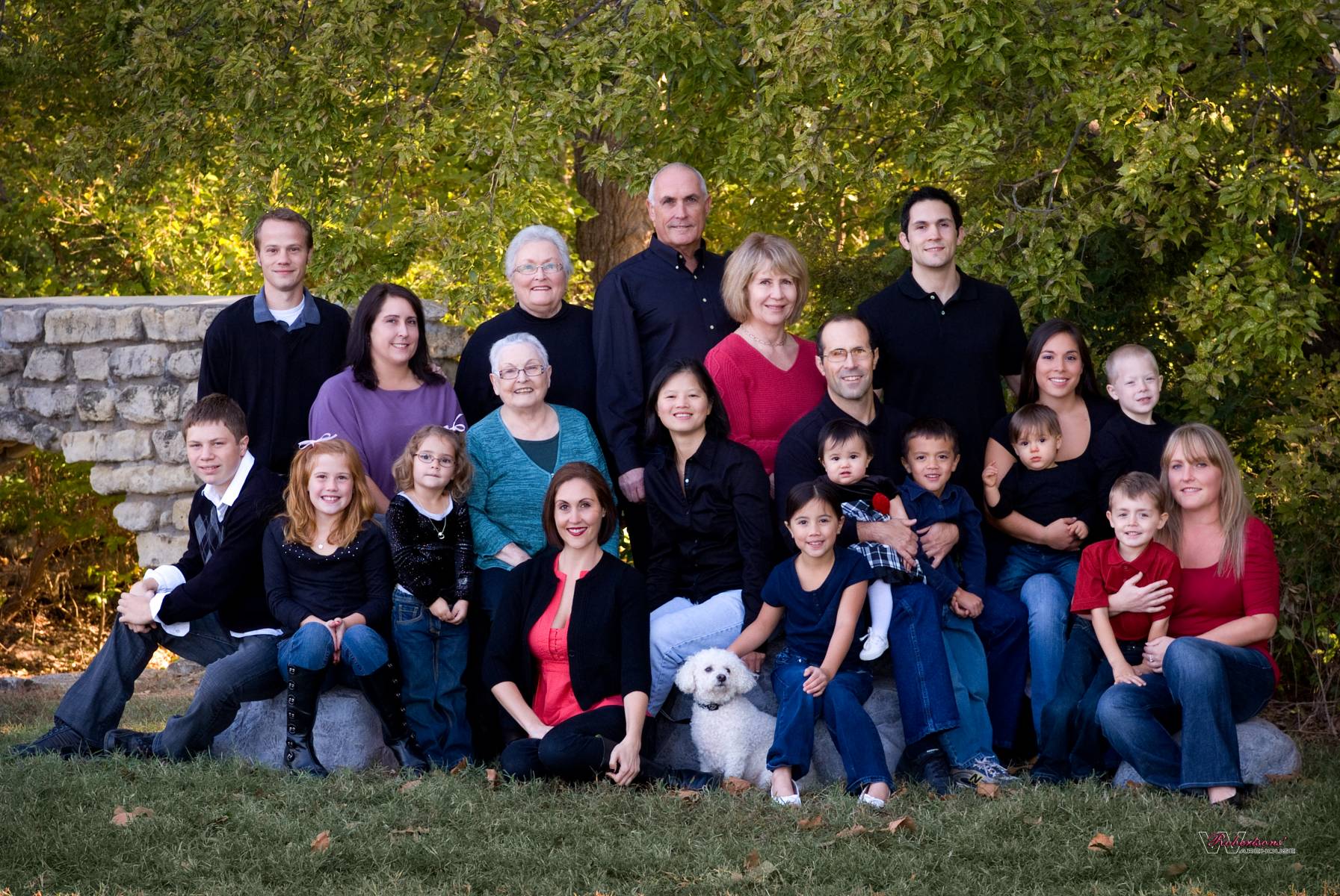 4 generation extended family picture of the Goodman family photographed in the open, surrounded by dense green vegetation, by Robertsons' Warehouse Photography, Wichita, KS