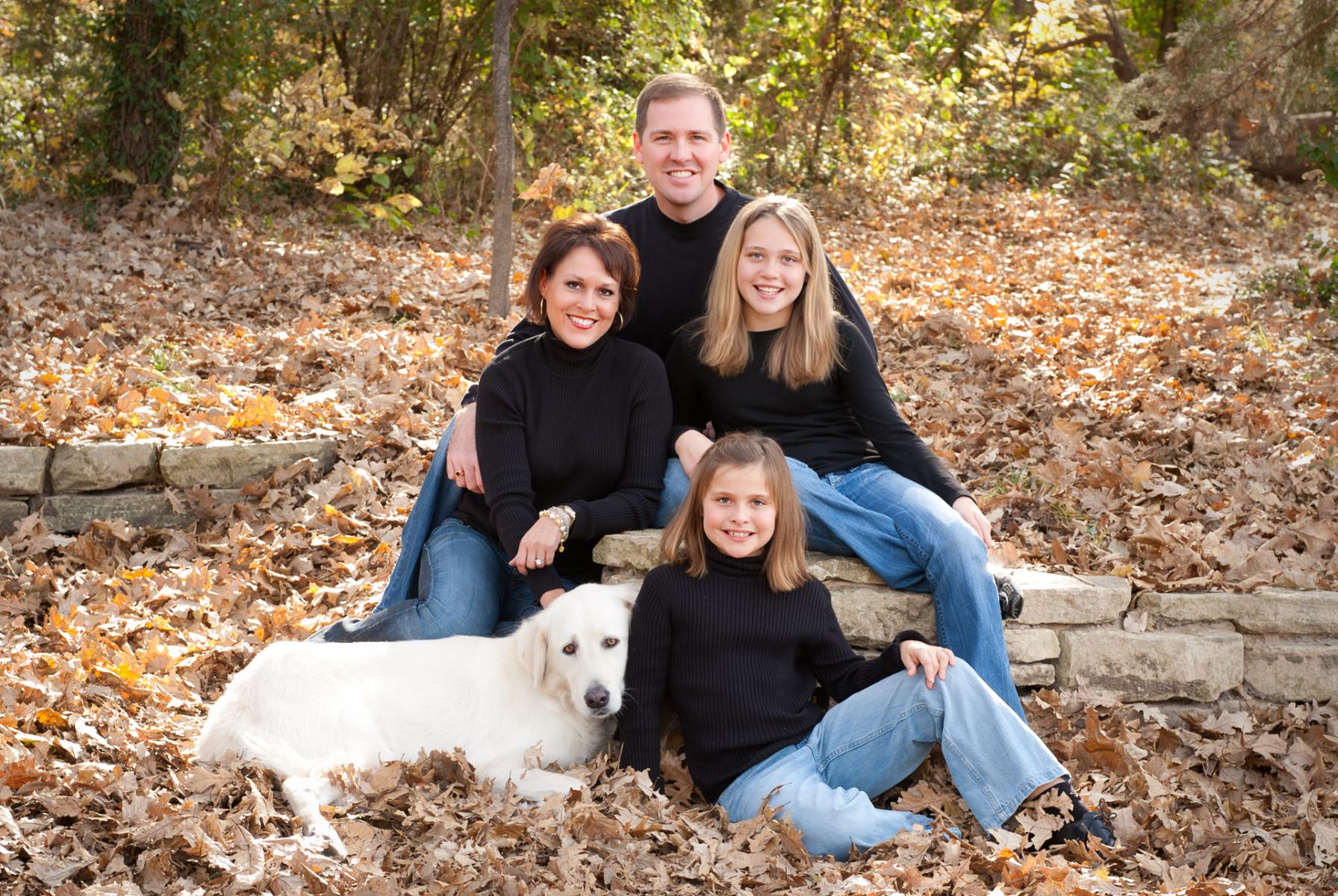 Fun portrait of a single unit family with their dog photographed in the open air surrounded by fall leaves, by Robertsons' Warehouse Photography, Wichita, KS